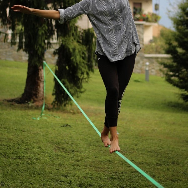 Caminando descalzo sobre la slackline en el parque
