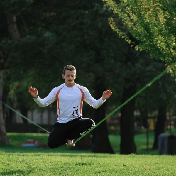 Saltando sobre la slackline montada entre dos árboles
